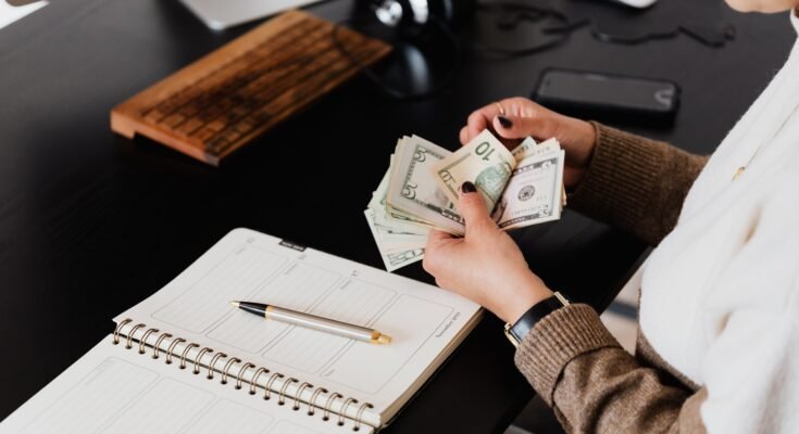 Woman counting freelance earnings from the Most Profitable Fiverr Services to Sell in 2026